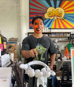 Man with a halloween face painting holding a skeleton hand