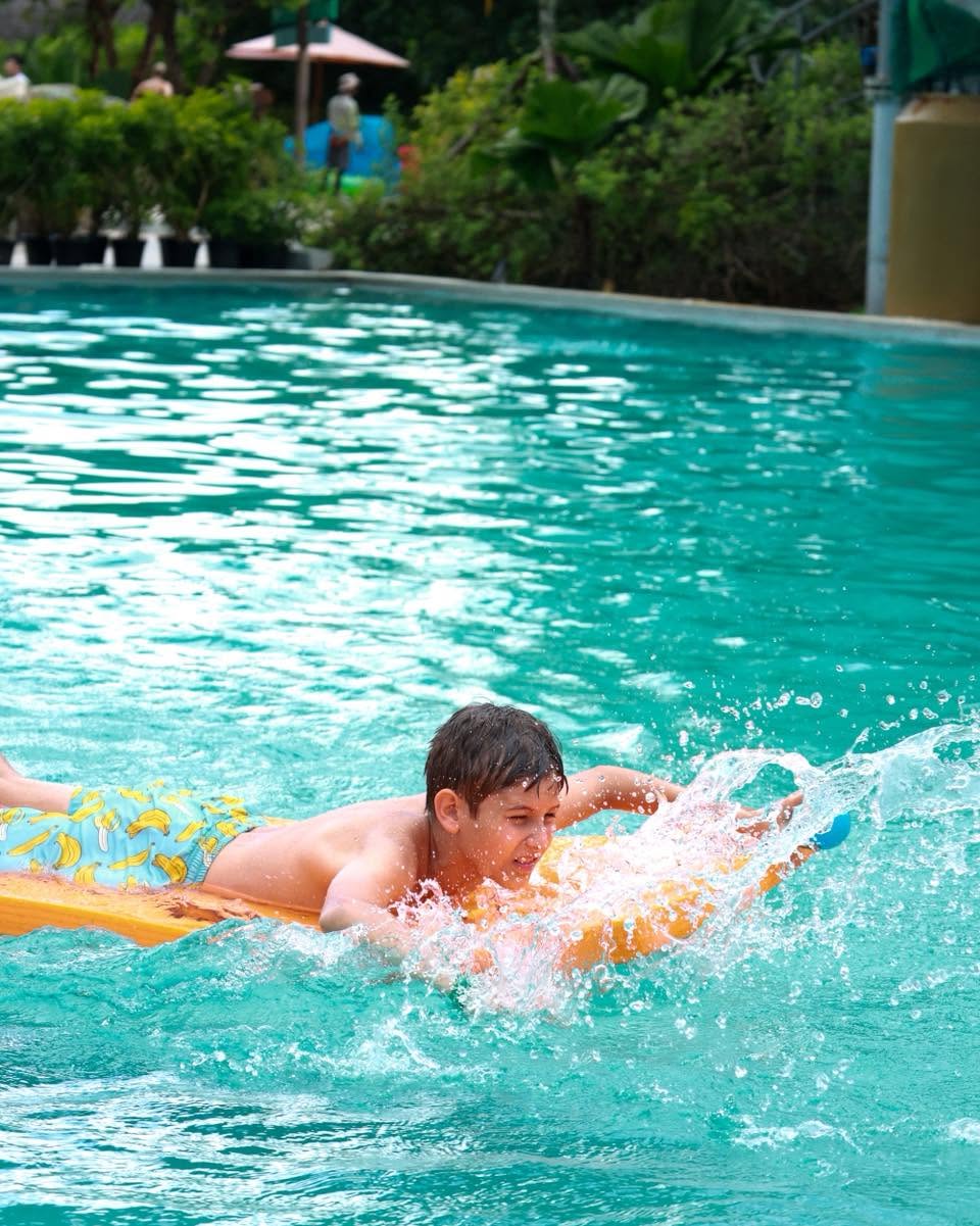 Lighthouse International School boy paddling with a board in the pool for YouTopia Phuket summer camp