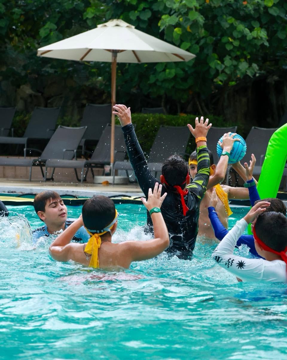 Lighthouse International School students playing volleyball in the pool